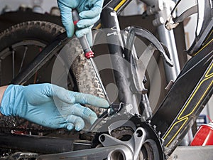 Hands of a man fixing the derailleur of a bike