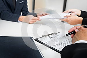 Hands of man giving application portfolio to HR man in office for interview. photo