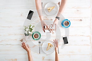 Hands of man giving present to woman on wooden table