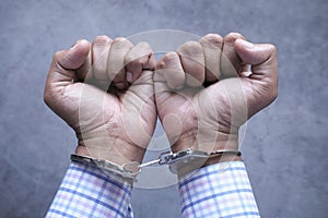 Hands of a man with handcuffs close up.