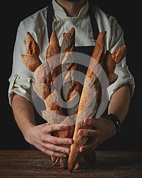 Hands of man holding baguettes photo