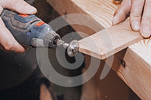 Hands of a man holding Dremel tool with an installed small cir photo