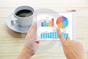 hands of a man holding graph business tablet device