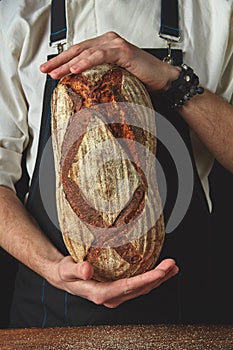 Hands of man holding oval bread