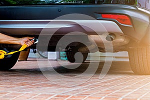 Hands of man holding yellow car towing strap with car