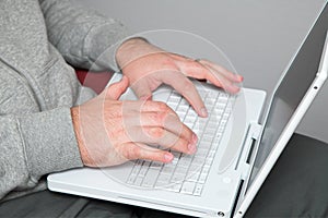 Hands of a man on laptop keyboard