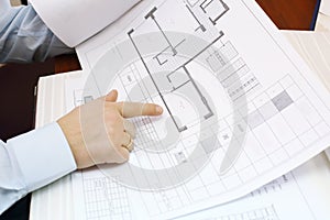 Hands of man looking drawings of apartment