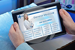 Hands of a man looking website of health service in the tablet