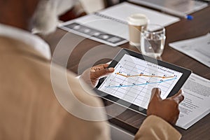 Hands of man in meeting with tablet, graphs and charts, stats for sales report, data and information in office. Business