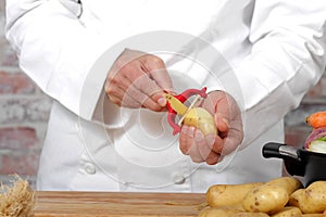 Hands of a man peeling potato with peeler