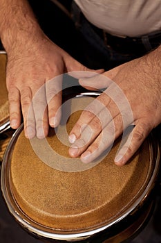 Hands of man playing the bongos