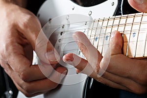 Hands of man playing electric guitar closeup