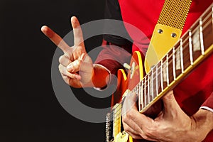 Hands of man playing the electric guitar on dark background