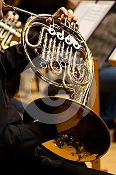 Hands of the man playing the French horn