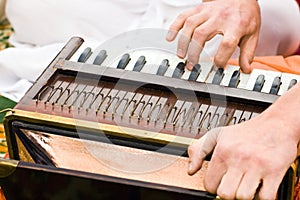 Hands of man playing mantra on accordion