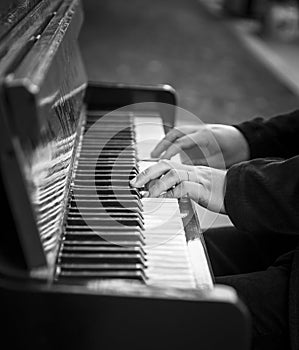 Hands of man playing an old piano