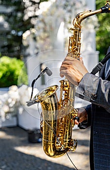 Hands of man playing saxophone. Close up view of the hands of a male saxophonist playing a tenor saxophone