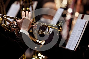 Hands of man playing the trumpet in the orchestra