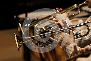 Hands of man playing the trumpet in the orchestra
