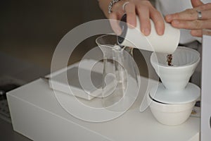 Hands of man prepared water in the machine for make coffee drip process