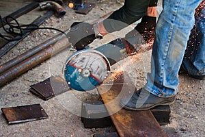 Hands of man with steel cutter tool. The worker outside, cuts the sheet of metal. Electrical saw generating hot sparks.