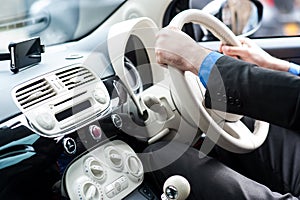 Hands of a man on steering wheel of a car