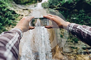 Hands Of Man Taking Photo Of Waterfall With His Smartphone Development Technologies For Tourism Concept