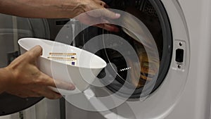 hands of man throw 50 euros banknotes into a washing machine. illegal cash and mafia money laundering, tax evasion