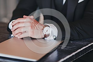 Hands of man with a watch and laptop