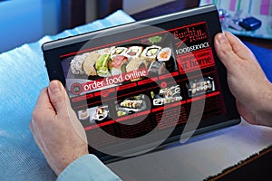 hands of a man in a website of a restaurant food delivery service in the tablet