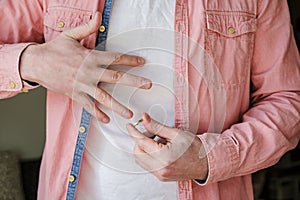 Hands of a man who puts on a golden, engagement ring after leaving his mistress.