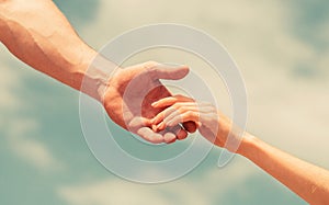 Hands of man and woman on blue sky background. Lending a helping hand. Solidarity, compassion, and charity, rescue