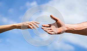 Hands of man and woman on blue sky background. Lending a helping hand. Solidarity, compassion, and charity, rescue