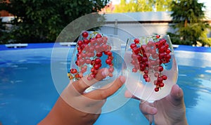 the hands of a man and a woman are holding glasses with a non-alcoholic refreshing summer cocktail on the background of