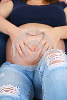 hands of a man and a woman on a pregnant belly, close up, Pregnant woman and her husband holding hand together, two