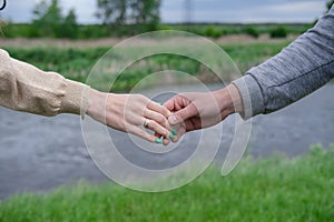 Hands of man and woman reaching to each other. Soft, gentle touch of hands on background of nature. Be hand in hand