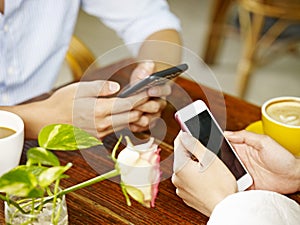 Hands of man and woman using cellphones