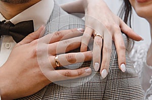 Hands of man and woman with wedding rings. Gold rings on the hands of the newlyweds