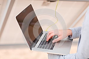 Hands of a man working on a laptop.