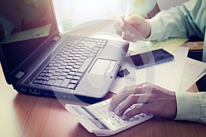 Hands of a man working on office desk in shinning light