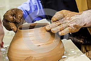 Hands of man working and shaping clay, potter in pottery