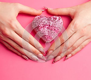 Hands with manicure folded in the shape of heart