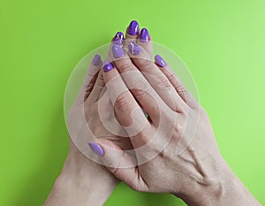 Hands manicure violet polish design on colored paper fashionable glamour minimal
