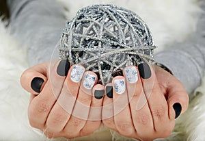 Hands with manicured nails colored with black and white nail polish