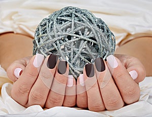 Hands with manicured nails colored with pink and purple nail polish