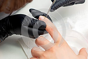 Beautician cutting cuticles of woman photo