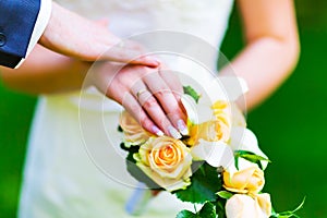 Hands of married bride and groom with golden wedding rings