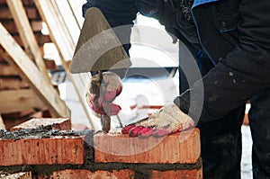 Hands of a mason at bricklaying
