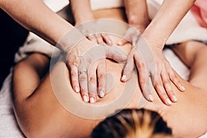 4 hands massage - two masseurs work simultaneously on the patient back photo