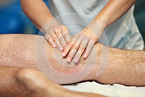 Hands massaging athlete's thigh after running